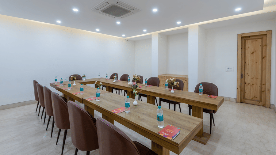 Side view of a conference room featuring two long tables arranged with chairs, set up for a meeting or event at DLS The Classio